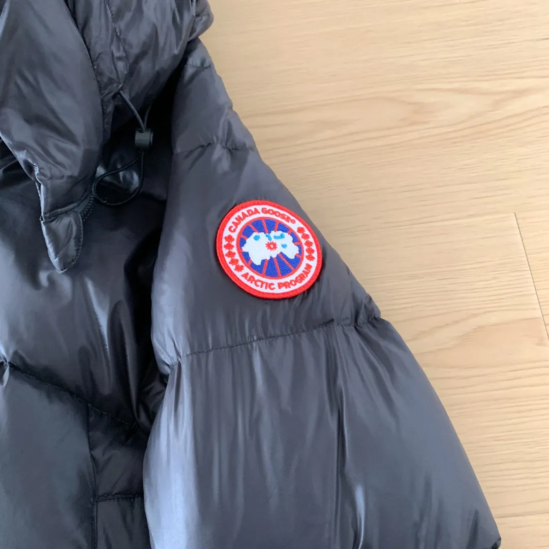 Style number: Y 166 2239L women's model (high version) Canada goose Cypress down jacket Cypress Series' New Arrival allows you to show your difference. This down jacket is an ideal winter piece. This style is filled with white duck down. Featuring a thin, channel-filled construction with lightweight fabrics and trim, it feels lightweight and adds warmth. The suede knit stand-up collar that protects the chin is soft and adds comfort. An adjustable down hood with cord closure adds warmth and protection against the elements. The back is designed with the iconic double-stripe Black reflective decorative stripes, making you more visible in dim environments. The inner layer has removable elastic straps, making the jacket easy to carry on the shoulder and hands-free. The side zipper gusset is breathable when moving. Color: Black Red Label Silver Birch Size: XS-2XL